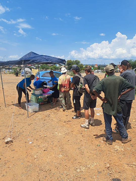 Guests queuing for their Christmas Lunch in Centurion.