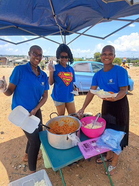 Volunteers Patricia, Vicky and Christy serving food in Centurion.
