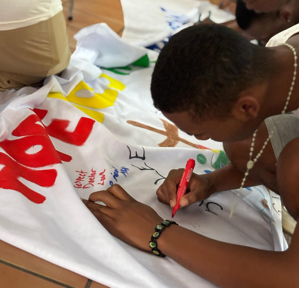 A person writing dreams and hopes on a cloth.